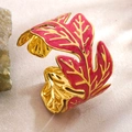 Elegant gold-tone stainless steel leaf cuff bracelet with vibrant magenta enamel details - Red