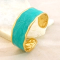 Vista macro di un bracciale rigido dorato con bordi irregolari e smalto effetto marmo blu - FYD6251SZ / Blu