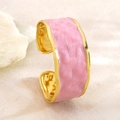 Dettaglio del bracciale a polsino dorato con bordi ondulati, smalto rosa e trama martellata - FYD6251SZ / Rosa