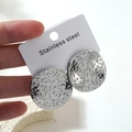 Gros plan sur des boucles d'oreilles en acier inoxydable argenté à texture étoilée - Style Rond Géométrique Texture Étoile (HQ6021)
