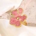 Macro detail of adjustable golden flower ring with pink enamel petals on stone texture - Pink