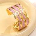 Dettaglio di un ampio bracciale dorato con smalto marmorizzato rosa e bordi ondulati - Rosa (FYD6206SZ-pink)