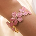 Golden stainless steel open bangle with three pink enamel flowers on a woman's wrist - Pink (FYD6209SZ-pink)
