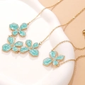 Detailansicht der mintgrünen Emaille-Blütenanhänger an einer goldenen Halskette - Blaue Emaille Blumen Halskette (FYD6217XL)