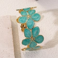 Detail van een vergulde open armband met vijf groene emaille bloemen en marmertextuur - Blauw
