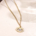 Macro shot of gold Evil Eye necklace with sparkling white zircons and blue center stone - Blue Zircon Evil Eye (D15)
