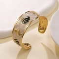 Golden sea shell cuff bracelet with marble enamel inlay and ocean themed relief detail - Black