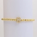 Golden beaded bracelet featuring a micro-pave crystal letter H charm on white stand - Letter H