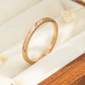 Macro-opname van roségouden titanium ring met gefacetteerde details in een geschenkdoos - Maat 5 / Diagonale Golf Stijl (R041) / Roségoud