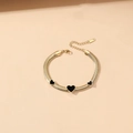 Detail eines goldenen Schlangenkettenarmbands mit drei schwarzen Herzen und Hummerverschluss - 17+5cm / Armband mit Schwarzem Herzanhänger