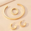 Detalle de set de joyas doradas con grabados de estrellas y circonitas brillantes - Combinación Brazalete Pendientes Anillo Estrella Dorado