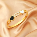 Elegant gold titanium heart bangle with black and white inlay on champagne silk background - Gold