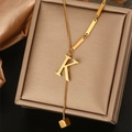 Detail van gouden ketting met hanger letter K en metalen staaf op sieradendoos - Letter K (WY006-K)
