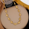 Dettaglio della collana a maglie a goccia dorata con finitura a specchio su un piedistallo - Collana Goccia d'Acqua (H1085)