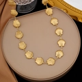 Collana a conchiglia dorata con texture opaca su un supporto circolare beige elegante - Collana Conchiglia Grande (H348)