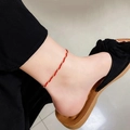 Bracelet de cheville minimaliste en acier titane rouge et or pour femme porté - Chevillère en Corde Rouge Enveloppée de Fil d'Or (QYB27)