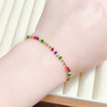 Colorful beaded bracelet with gold round beads and vibrant triangle charms on a wrist - Four Color Rhinestone Bracelet (E2061) / Gold