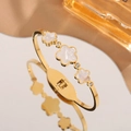 Bracelet élégant en acier titane doré avec trois motifs de fleurs en nacre sertis - Or