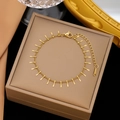 Detailaufnahme einer goldenen Edelstahl-Fußkette mit kleinen Stabanhaengern in einer Box - Y-Armband (Gold)