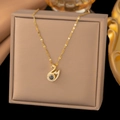 Macro shot of gold swan pendant necklace featuring 100 languages I love you projection stone - Gold