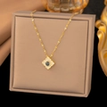Macro detail of a floral gold necklace featuring a blue gemstone and white decorative stones - Gold