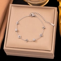Silver stainless steel bracelet with star and flower charms on a leather jewelry box - Cube Flower Bracelet (E265) / Silver