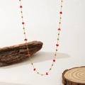 Detail of gold chain necklace featuring red faceted crystals and golden cube beads - Red Zirconia Square Necklace (QYH1033) / Gold