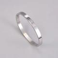 Detailed macro view of mirror-polished silver titanium steel bangle with side hinge clasp - Silver