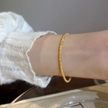 Minimalistisches vergoldetes Armband mit funkelndem Hammerschlag-Effekt am Handgelenk getragen - Sternenklare Wasserwellen-Kette Armband / Gold