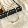 Close-up of heart pendant and silver textured chain on a minimalist display tray - Heart Style / Silver