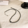 Detail van donkergrijze hematiet kralenketting met een minimalistische zeshoek hanger - Ruitstijl