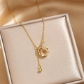 Edle Goldkette mit Doppelring-Anhänger und Zirkonia-Besatz auf feinem Satin-Hintergrund - Gold Quaste Doppelring Halskette