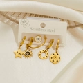 Detail of gold-plated stainless steel star and evil eye earrings on white satin - Star Sun Style