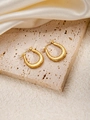 Detailed view of gold twisted U-shaped hoop earrings on elegant beige stone tray - U-Shaped E0174 Style