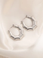 Detail van zilveren titanium stalen oorringen met geometrische schubbentextuur - Bamboe Zeshoek Stijl (BJGE0223)