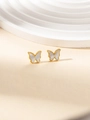 Detailansicht goldener Schmetterlingsohrringe mit weißer Muschel auf Displayständer - Schmetterling-Ohrstecker (BJGE0597)