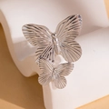 Silver butterfly ring with brushed petal texture on a modern minimalist display stand - Silver Double Butterfly Ring