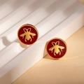 Detail von roten Emaille-Bienensteckern mit Gold-Finish auf einem weißen Display - Rote Ohrstecker (ZYGE1301)