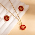 Dettaglio di orecchini e collana con api dorate e inserti in smalto rosso vivace - Set di Gioielli Rosso (ZYGS0140)