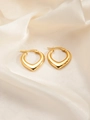 Macro shot of polished gold heart-shaped earrings on cream textured silk fabric - Heart E0165 Style