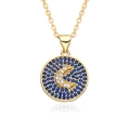 Gros plan détaillé d'un collier pendentif lune doré avec pavé de zircons bleus et blancs - Style Rond Croissant de Lune Micro Pavé Bleu (E409)