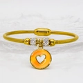 Detail of gold snake chain bracelet with orange heart charm and magnetic clasp - 16cm