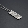 Macro shot of silver dollar sign pendant necklace featuring detailed $100 bill engraving - Silver