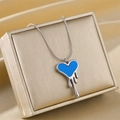 Detail of melting blue heart pendant on silver snake chain over gold jewelry box - Silver Blue