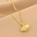 Goldene Muschelhalskette mit weißer Perle und funkelnden Kristallen auf weichem Stoff - Gold