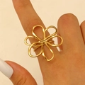 Close-up of golden hollow five-petal flower ring on finger with modern wire design - Gold (8539)