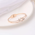 Detailed macro view of rose gold bangle with shell four-leaf flower and zircon inlay - Rose Gold
