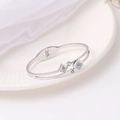 Silver titanium steel bangle featuring shell clover flowers and crystals on a white plate - Silver