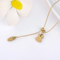 Macro shot of polished gold bunny and carrot charms on a delicate stainless steel chain - Gold