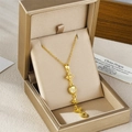Long tassel necklace with clover heart pendants and rhinestones in a gold jewelry box - Gold